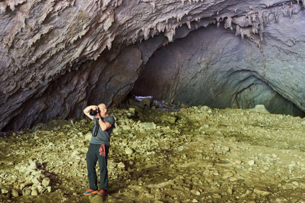 istock Nature photographer shooting in a cave 1437717797