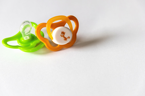 Two baby pacifiers on a white background.