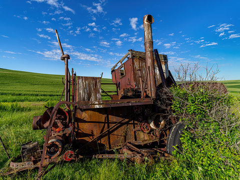 Rusted and crumbling farm equipment in a field