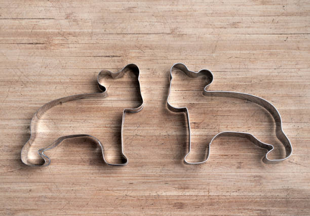 Bear cookie cutters facing each other wood board.