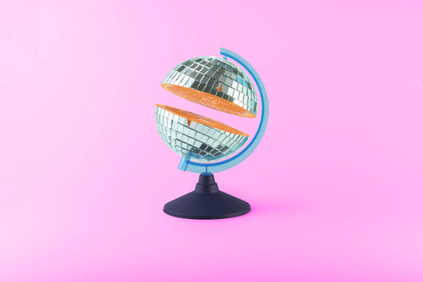 istock Globe with cut disco ball with orange inside on purple background. Creative fruit collage. 1437725921