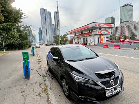 Moscow, Russia - September 11, 2022: Electric car charging on Moscow street, car is Nissan belongs to car sharing system Yandex.Drive