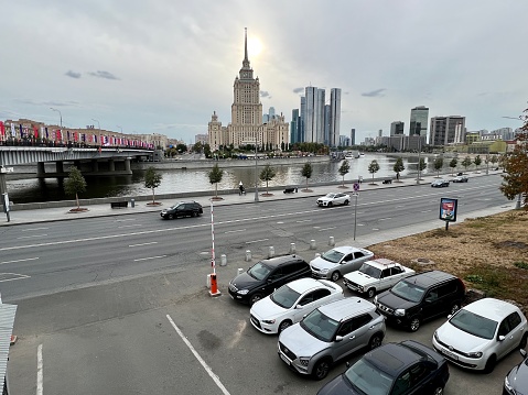 Moscow, Russia - April 29, 2019: Embankment and city traffic near Zaryadye park, Kremlin towers and St Basil Cathedral in sunny day