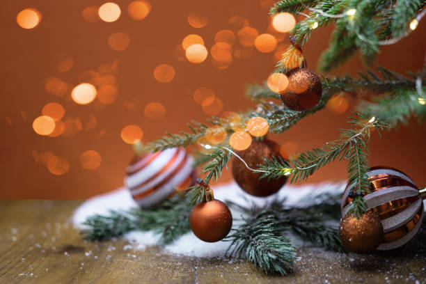 fête de noël fête de noël bannière de fond carte de vœux - boules de noël modernes de couleur cuivre, boules de noël sur sapin de sapin de noël, sur table en bois enneigé - noble fir photos et images de collection