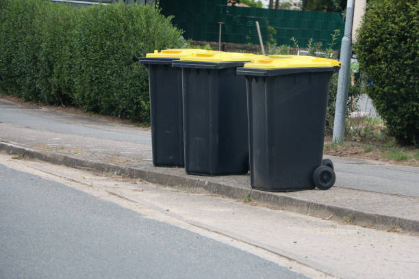 many plastic rubbish bins stand in a row on the side of the road stock photo