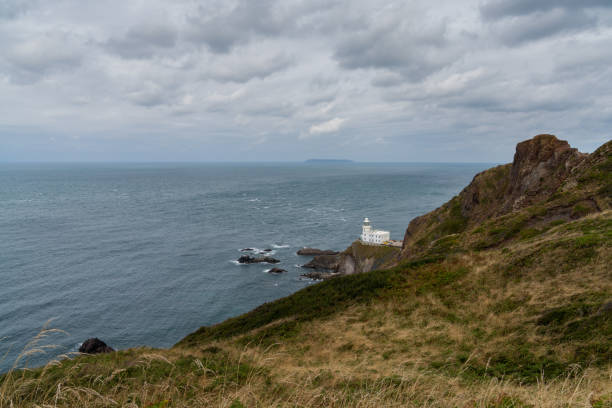 vue du phare historique de hartland point et du promontoire sur la baie de bristol - hartland point lighthouse photos et images de collection