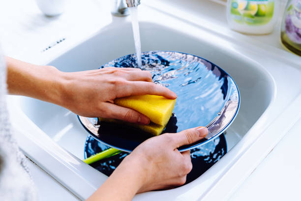 istock Housewife washes dishes in kitchen sink 1437732708