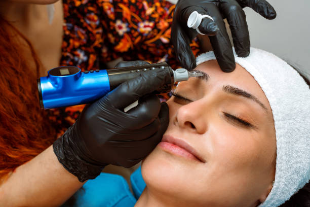 istock Beautician applying permanent make-up to beautiful woman's eyebrows 1437733804