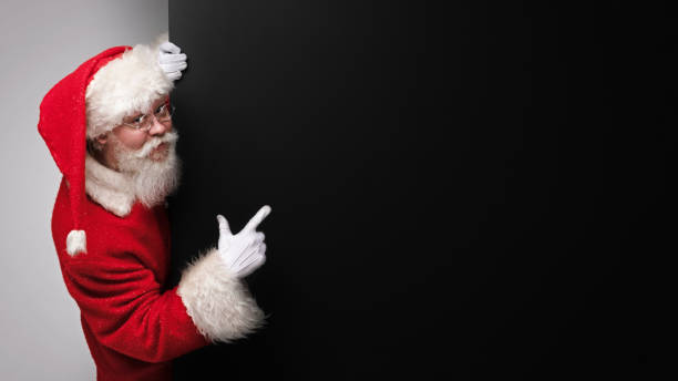 istock Santa Claus pointing at banner 1437734596