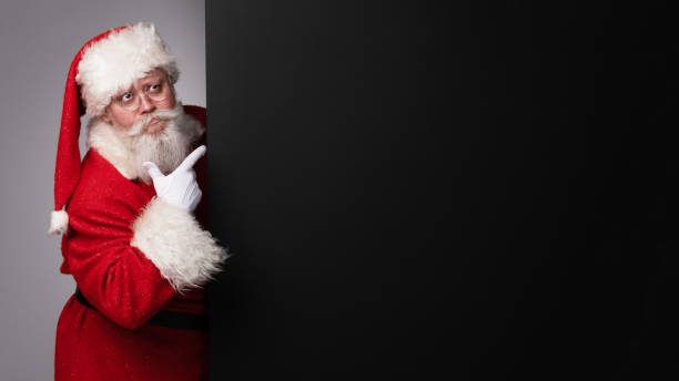 istock Santa Claus pointing at banner 1437734630