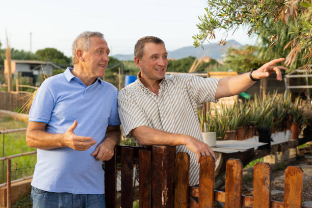 istock Two men neighbors standing at fence and chatting 1437736938