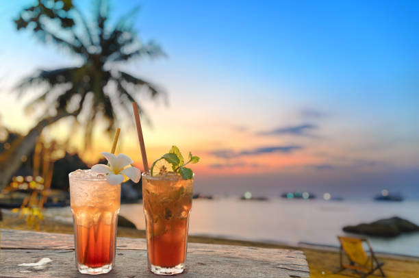 ぼかしビーチと背景に夕日と飲み物 - drink alcohol summer celebration ストックフォトと画像