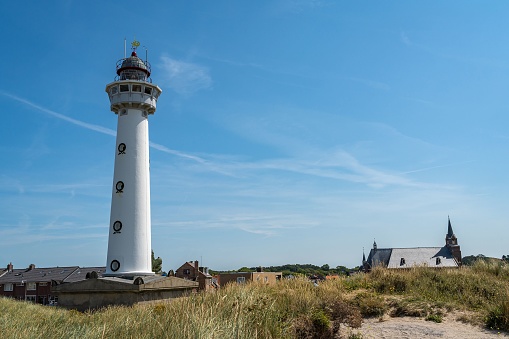 Lighthouse and the church in dutch coastal village Egmond aan Zee