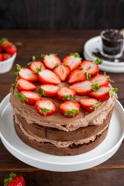 istock Naked chocolate cake with cream and fresh strawberries on top. Rustic style. Selective focus. Copy space. 1437739590