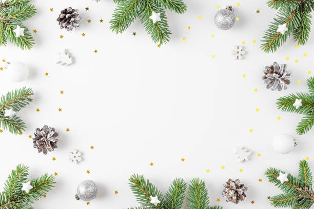 istock Christmas frame made of fir tree, festive silver decorations on white background. Flat lay. Minimal layout 1437739761