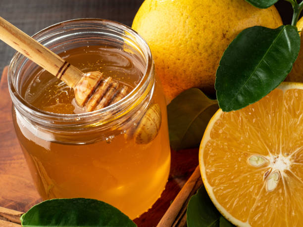 istock Honey bee with oranges and cinnamon on a wooden board. 1437739804
