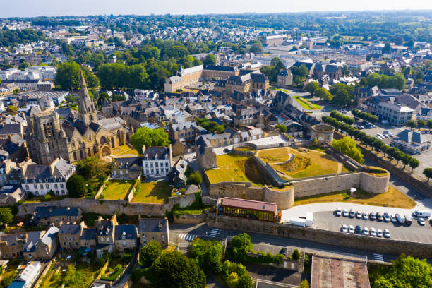 Drone view of Guingamp with Basilica and castle walls, France Scenic drone view of summer cityscape of Guingamp with Gothic Basilica of Notre Dame de Bon Secours and medieval castle walls, France guingamp stock pictures, royalty-free photos & images