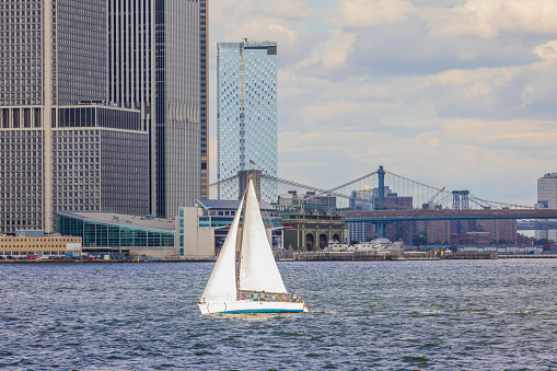 View of white sailboat with tourists on Manhattan buildings background. USA. New York.