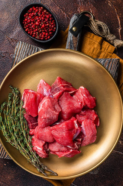 istock Raw diced lamb mutton meat with thyme. Dark background. Top view 1437747062