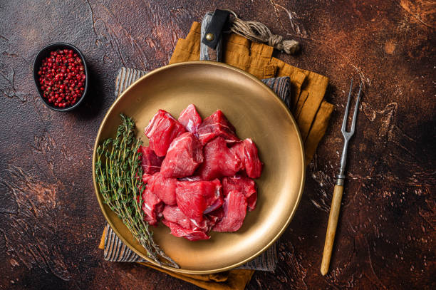 istock Raw diced lamb mutton meat with thyme. Dark background. Top view 1437747070