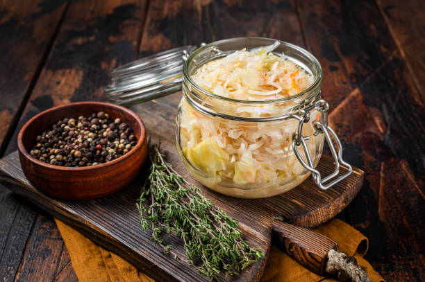 自家製ザワークラウト、黒コショウ、タイムのガラス瓶。木製の背景。トップビュー - sauerkraut salad coleslaw cabbage ストックフォトと画像