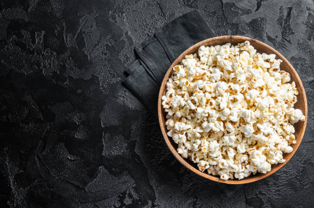 istock Salted popcorn in a wooden plate. White background. Top view. Copy space 1437750513