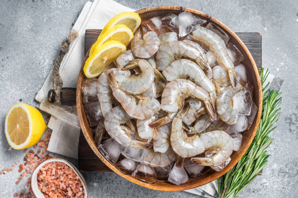 istock Uncooked Raw peeled tiger white shrimp prawn. Gray background. Top view 1437751398