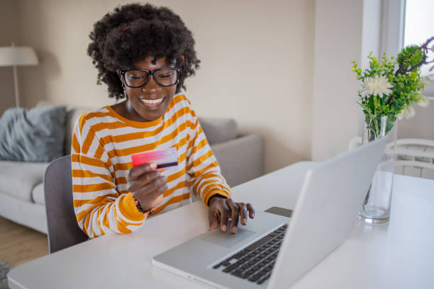 istock Cheerful  woman doing online shopping 1437752081