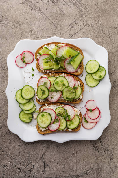 istock Three sandwiches with vegetables and vegetable cheese on a white square plate 1437753747