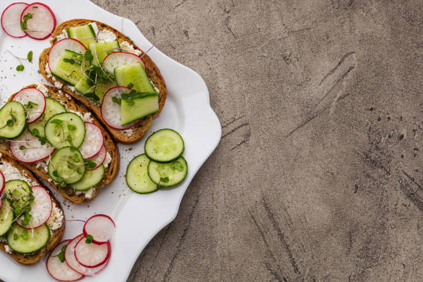 istock Three sandwiches with vegetables and vegetable cheese on a white square plate 1437753753