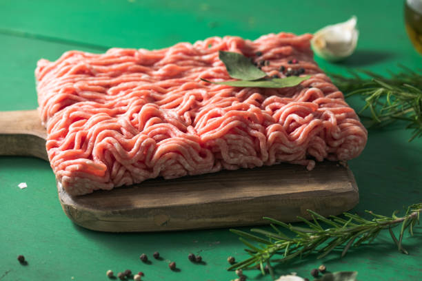 istock Raw Mince, minced Ground beef meat on a cutting board. Green background. Top view 1437754901