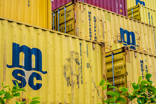 Gothenburg, Sweden - July 24 2022: Tall stack of yellow MSC shipping containers.