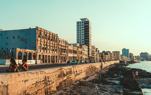Havana, Cuba - March 19, 2015:  Street scene with life on Malecon street in Havana, Cuba, with people jogging, drinking, listening to music or just chilling.