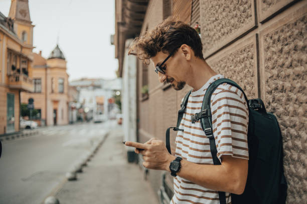 istock Man with backpack in the city using phone 1437769676