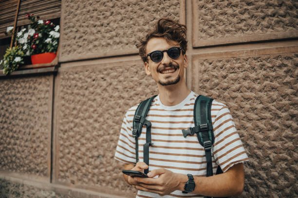 istock Man with backpack in the city using phone 1437769685