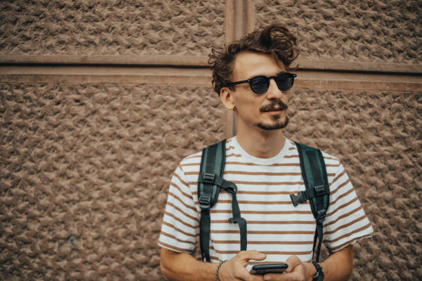 istock Man with backpack in the city using phone 1437769687