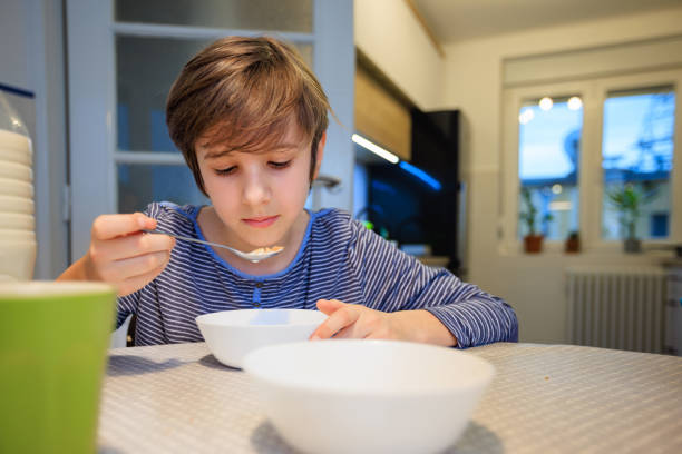 istock Boy eating cereal for breakfast at the table at home 1437772719