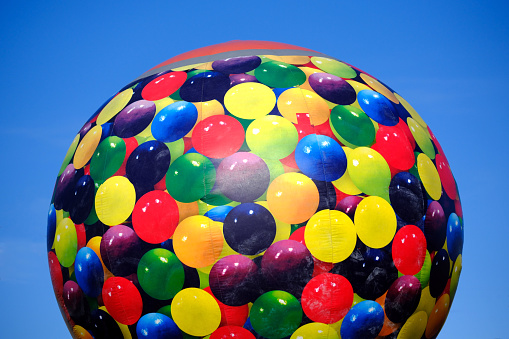 Multi color hot air balloon against blue sky.