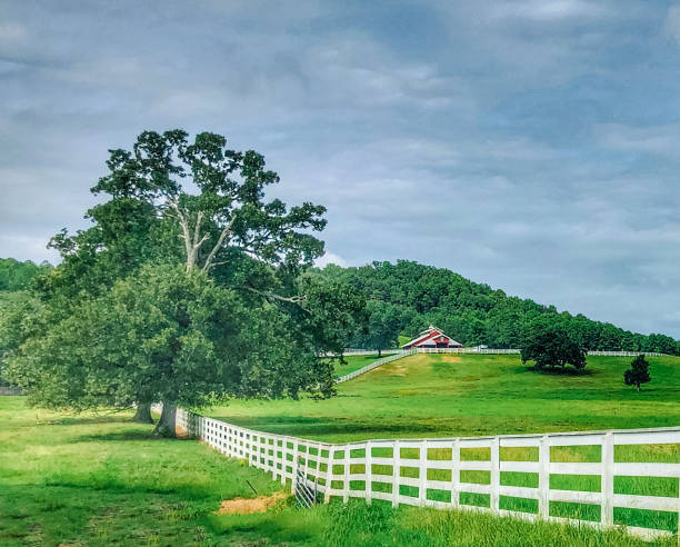 A red barn and white fence are part of a farm in Russellville, Arkansas