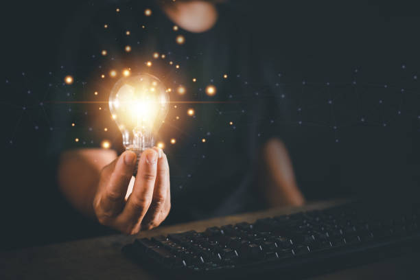 istock Man hand holding light bulb and using keyboard of computer , New idea creativity concept, Innovation and inspiration for business administration. 1437776752