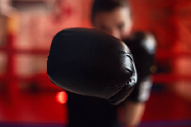 boxeadora entrenando en el gimnasio con guantes de boxeo puestos - boxing womens fotografías e imágenes de stock
