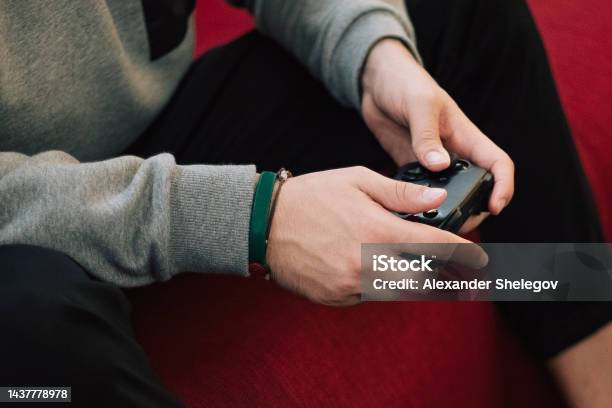 Photo Of Men Who Playing Video Game On Digital Console Indoors People Holding Gamepad In The Hands Xbox And Playstation Concept Photography Stock Photo - Download Image Now