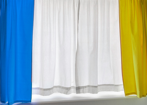 Blue and yellow curtains with white background, a symbol of the Ukrainian national flag