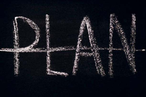 The inscription Plan crossed out in chalk on a black chalkboard. The concept of work or action without a plan. It is a big mistake in sports or business to not have an action plan
