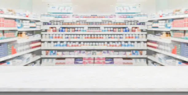 Photo of Empty white marble counter top with blur pharmacy drugstore shelves background