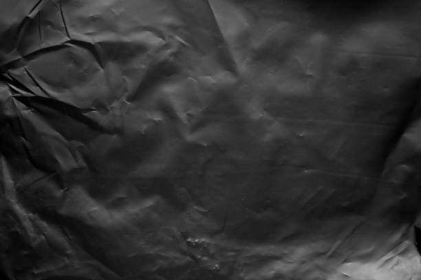 istock transparent plastic bag film wrap overlay texture on black background 1437781419