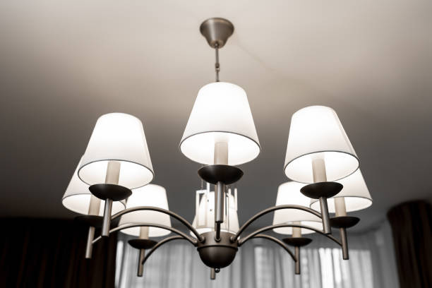 istock A round chandelier of several lamps against a light ceiling, full frame, side view 1437782239