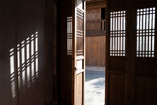 The sun shines on the wooden door of the ancient street