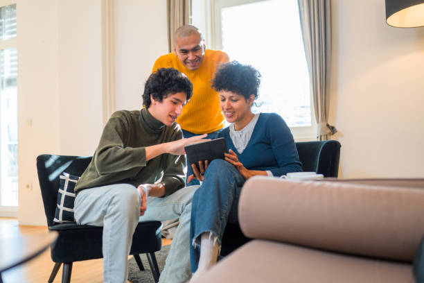 istock Hispanic Family Using Digital Tablet Together in Living Room 1437784398