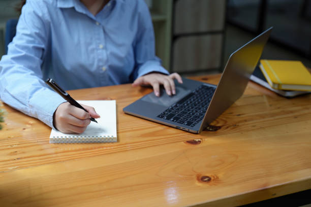 istock Portrait of a beautiful Asian employee working using a notebook and using a laptop computer 1437790739